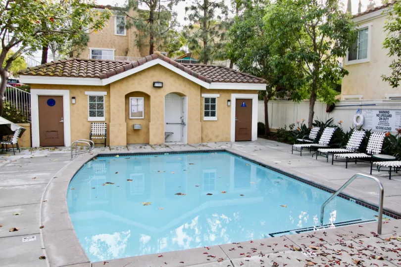 A sweet swimming pool in the Vista De Oro with some chairs and a sweet blinding near