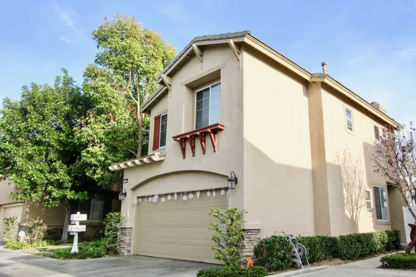 2 storey home with a double car attached garage, 2nd floor planter ledge and mature trees in Aliso Viejo