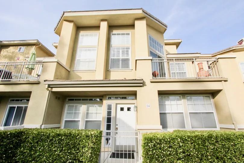This two story building in Vistas Above Wood Canyon has two balconies and a white iron gate.