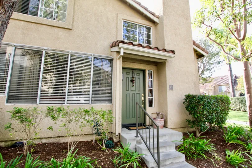 A NICE HOUSE WITH LIGHT YELLOW COLOR WITH INFRONT OF STEPS WITH NICE WINDOWS
