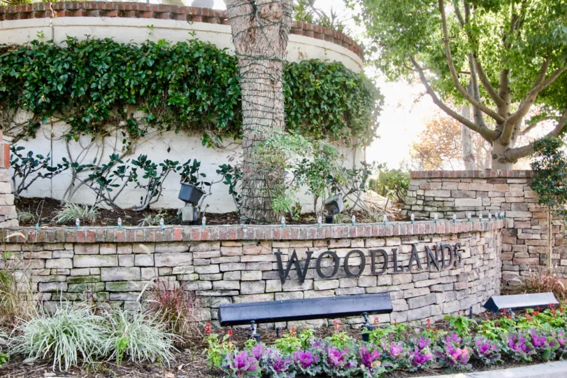 A beautiful day in the Woodlands with a sign on the bricks.