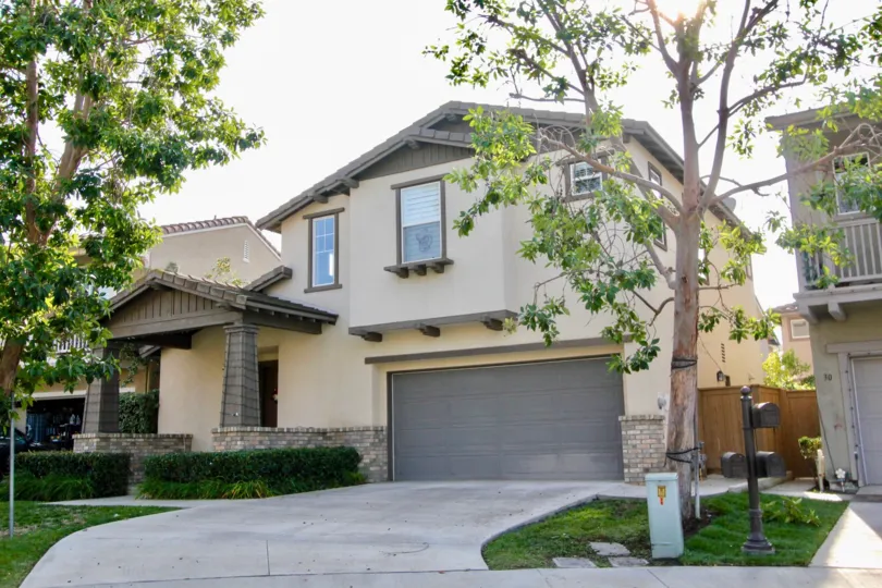 A beautiful home with driveway view and tree landscaping in the Woodlands community