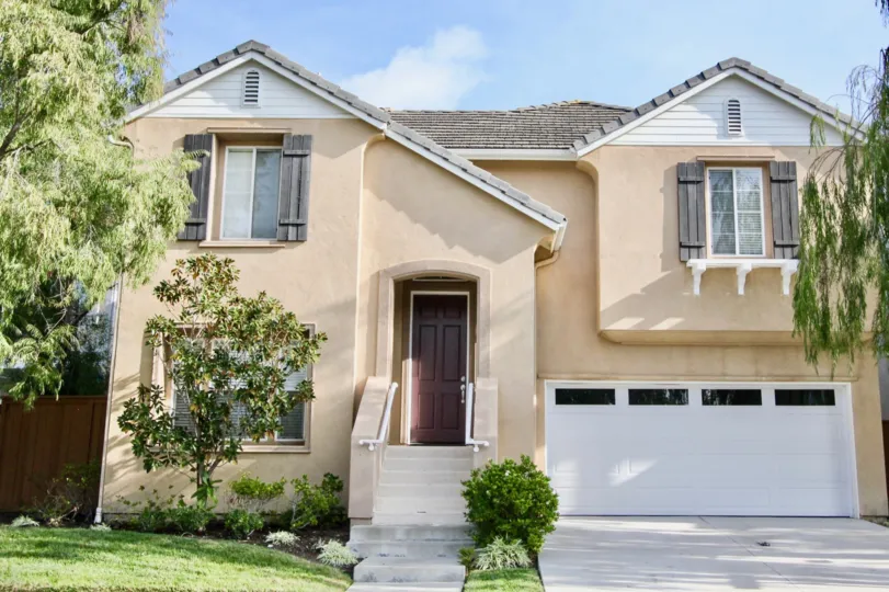 Two storey home on a wide lot with double car garage, decorative window shutters and mature trees in Woodlands