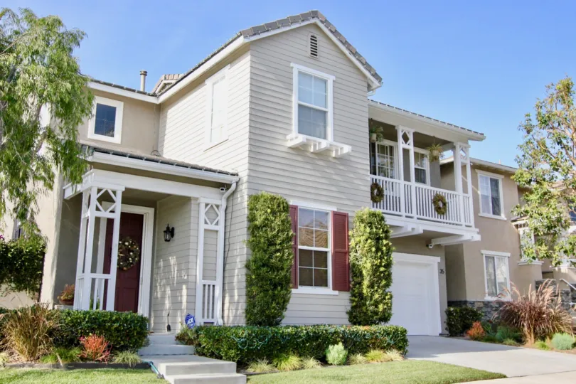 A sunny day in the Woodlands with a stylish house and plants.