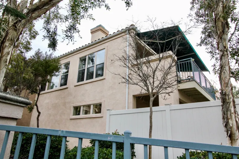 THIS SHOWS THE SIDE VIEW OF HOME WHICH HAS THE VERY BIG TREES, PLANTS, SHOWS THE GLASS WINDOWS ARE LOCATED IN THE CITY ANAHEIM HILLS