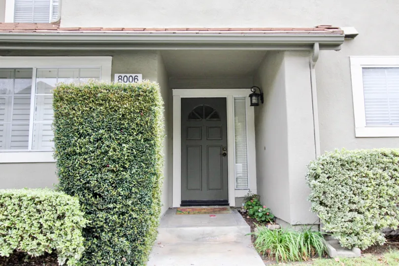 THE FRONT VIEW OF THE VILLA LOCATED IN ANAHEIM HILLS WHICH HAVE LOT OF PLANTS, NUMBER ON THE WALL