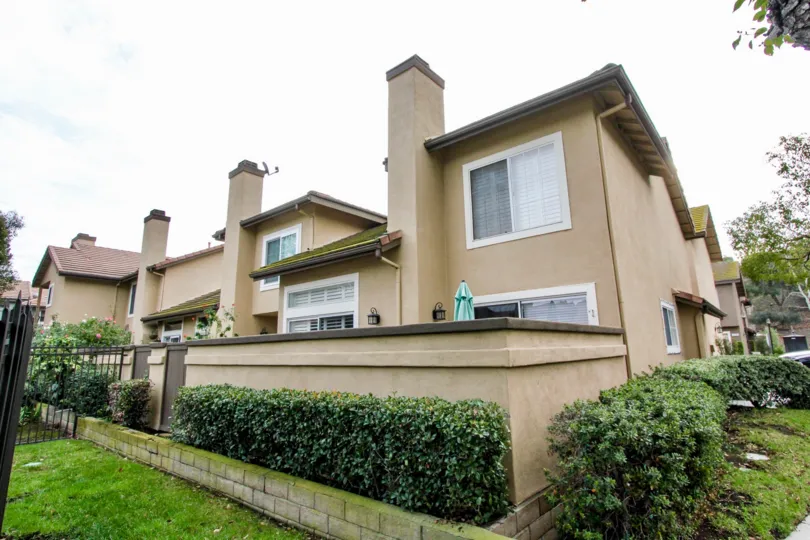 THE SIDEVIEW OF HOUSE WITH BEAUTIFUL LAWN, PLANTS, FLOWERS ARE THERE IN THE CITY OF ANAHEIM HILLS