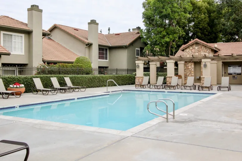THE FLAT IN THE Laurelwood at Sycamore Canyon WITH THE SWIMMING POOL, CHAIRS, PLANTS, TREES