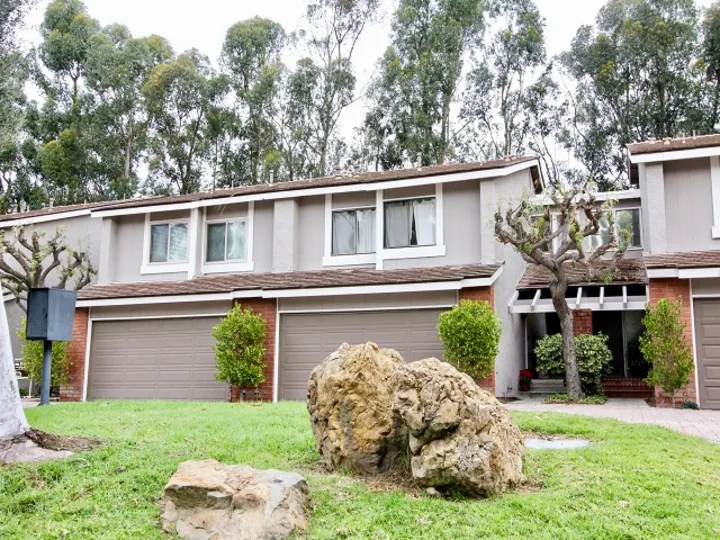 THE VILLAS IN THE PARKVIEW TOWNHOMES WITH THE LAWN, ROCK, PLANTS, TREES
