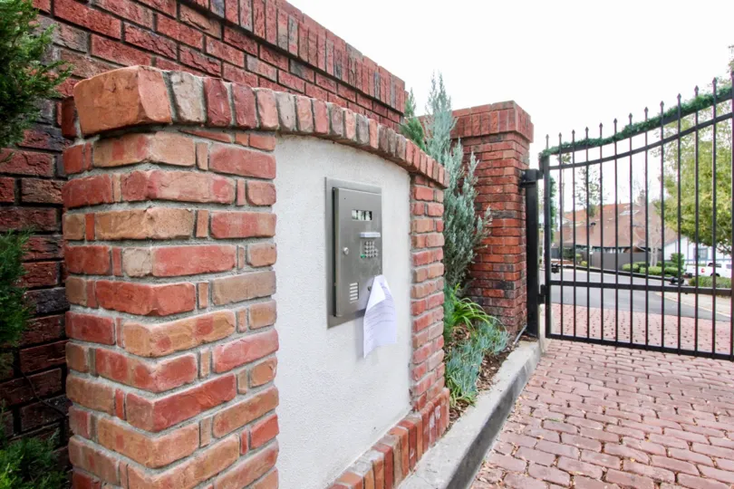 THE HOUSE IN THE RIMCREST VILLAS WITH THE ELECTRONIC BOX, PLANTS, TREES, GATE