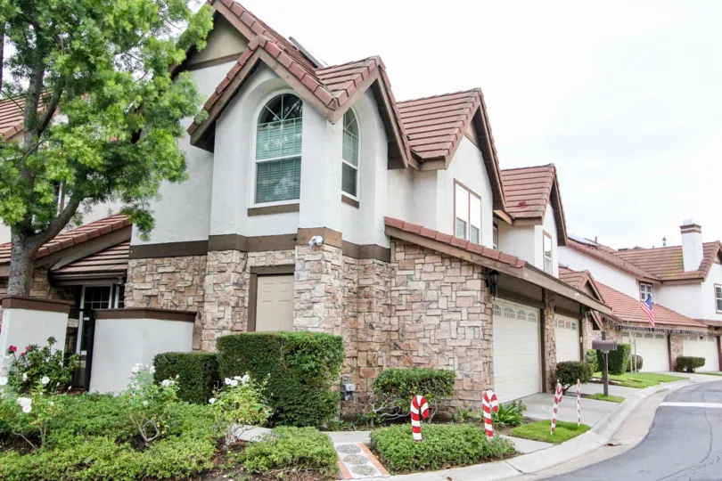 A row of two story homes with brick first floors and dry wall second floors at Royal Court Village in Anaheim Hills CA