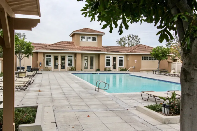 THE VILLAS IN THE SUMMIT PARK WITH THE SWIMMING POOL, CHAIRS, TREES