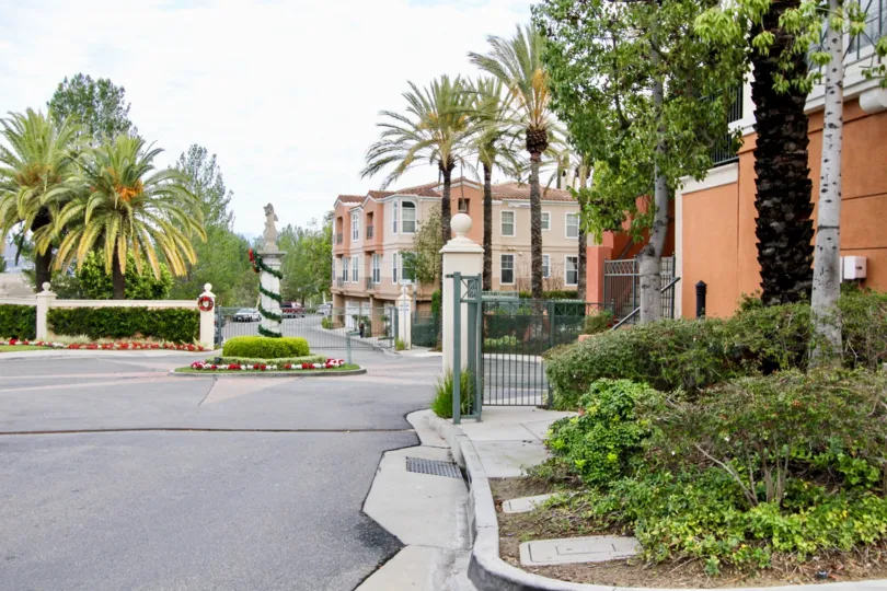 THIS IMAGE REPRESENTS THE APARTMENTS WITH LOTS OF PLANT, TREES, AND THE ROADWAY IN THE CITY OF ANAHEIM HILLS