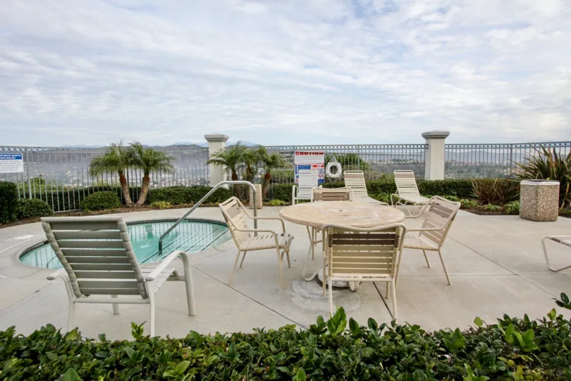 THE SMALL SWIMMING POOL SURROUNDED BY SMALL PLANTS, LAWN, CHAIRS ARE SHOWN IN THE CITY OF ANAHEIM HILLS