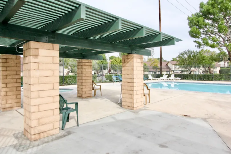 THIS IMAGE REPRESENTS THE SWIMMINGPOOL THAT LOOKS BEAUTIFUL, AND HAVE THE LOT OF CHAIRS, TREES, PLANTS WHICH IS SITUATED IN THE CITY OF ANAHEIM HILLS