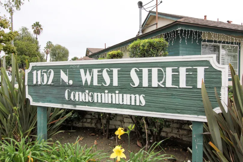 THIS IMAGE SHOWS THE NAME BOARD WITH PLANTS, TREES, AND FLOWERS SEEN IN 1152 NORTH WEST COMMUNITY