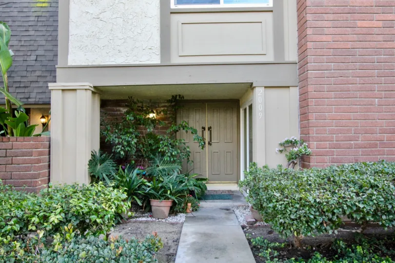 An entry path and front door of a brick home in Anaheim Gardens