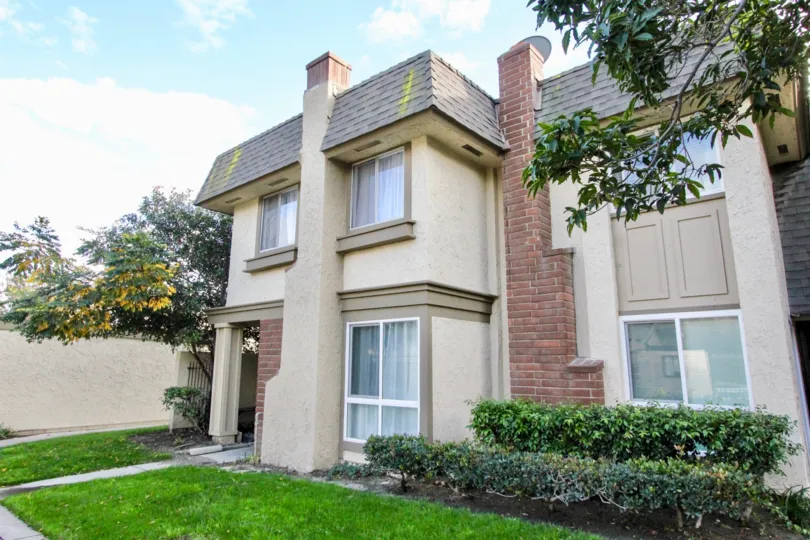 Hut style condominiums with a red brick chimney inside Anaheim Gardens in Anaheim CA