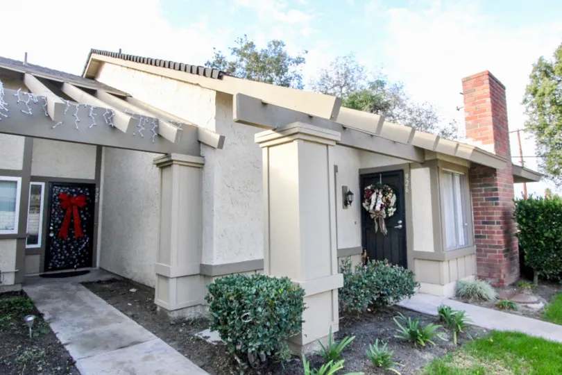 A sunny day in the Anaheim Gardens with a small building and plants.