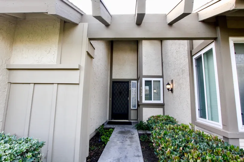 a warn day in the anaheim gardens with a building that has numbered as 932 and garden in front