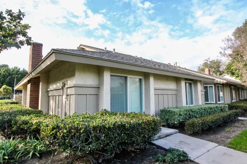 cutted bushes are present at both sides of the pathway in villa at Anaheim Gardens