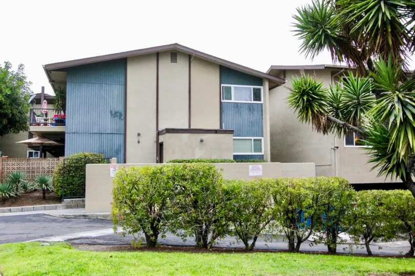 Two story brown and white condo behind security wall at Anaheim Village I in Anaheim CA