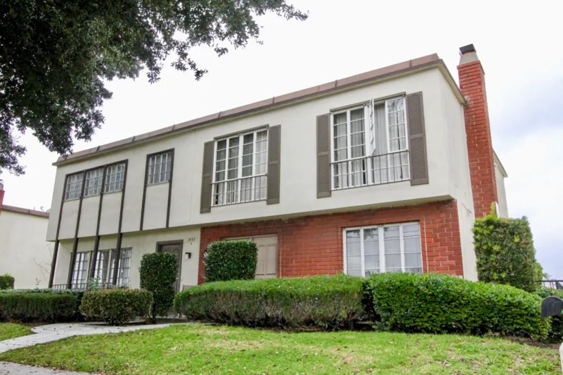 A street view of a home and front yard in Anaheim Village III on a cloudy day