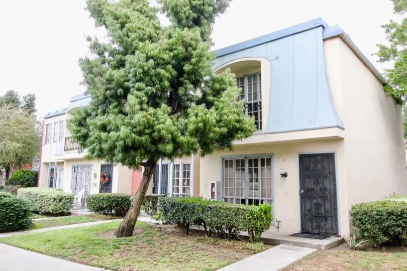 Small house with blue roof and tree in Anaheim Village III, Anaheim CA