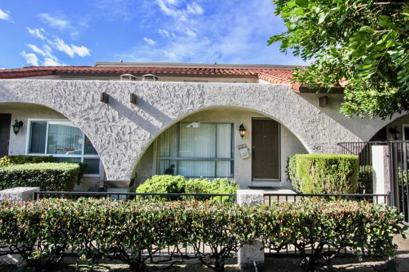 A street view of a home and landscaped yard on a sunny day at Aron Place