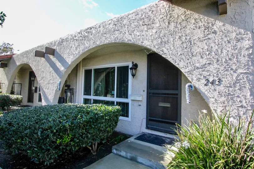 An entry path and front door of a stucco home in Aron Place