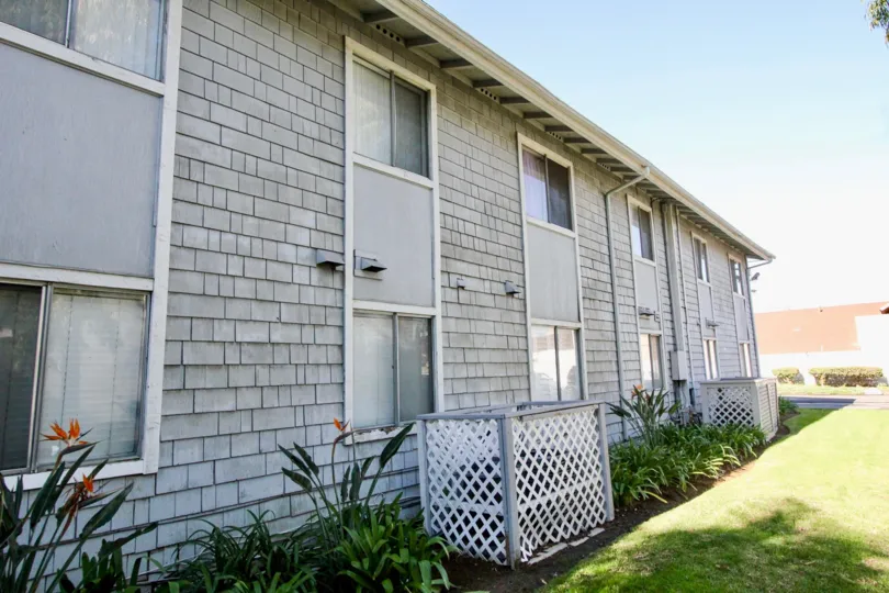 A large gray apartment building with wood shingle walls inside Brookhurst Village in Anaheim CA