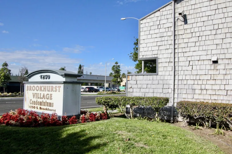 Gray letters welcome visitors to the Brookhurst Village on a sunny day.