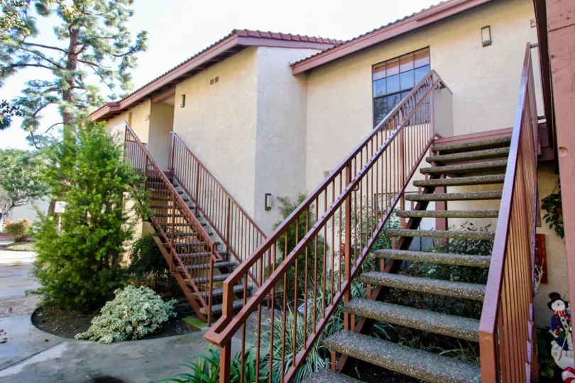 A two-storey housing in the Cameron Court community with exterior staircase painted in red.
