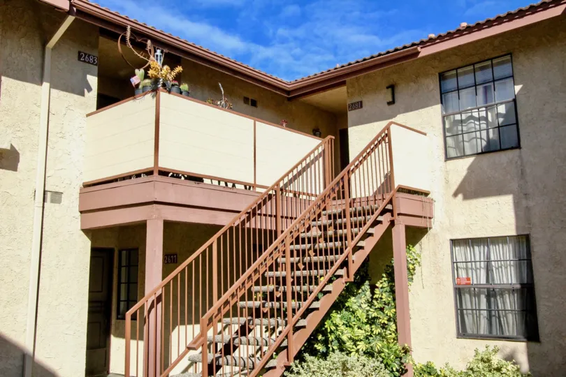 The stairs to an upper level of units at the Cameron Court community on a sunny day