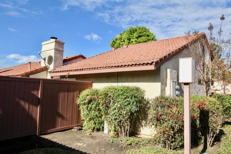 A back view of a home with landscaping and fence in Cameron Court on a sunny day