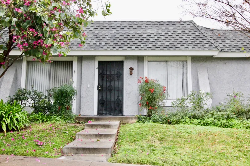 A simple bungalow in Casa Canon community with gated front door and gray roof tiles.