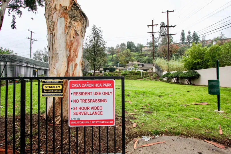 A gate with a "no trespassing" sign in front of a housing community