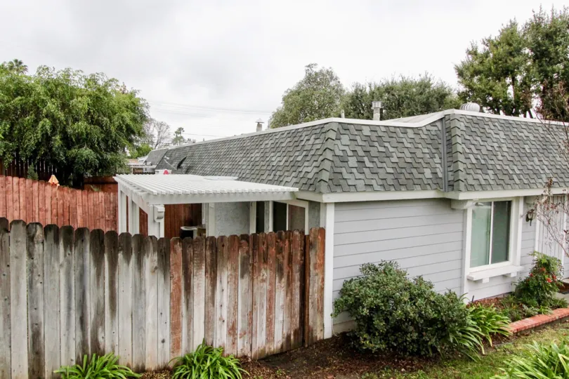 A simple bungalow in Casa Canon community with rickety wooden fence.