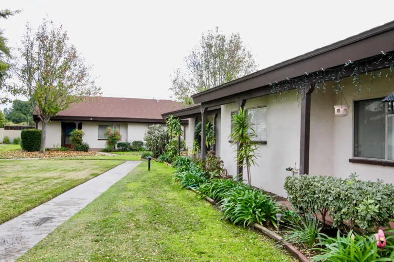 THIS IMAGE VIEWS THE HOME WITH BEAUTIFUL LAWN, PLANTS, PATHWAY IN THE CITY OF ANAHEIM