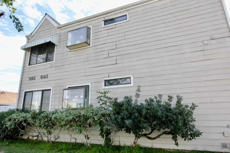 A WARM DAY IN THE Cerritos Manor WITH A BUILDING THAT HAS AROUND THE GARDEN AND CLOSED THE GLASS WINDOWS AND ROOFLESS TOP