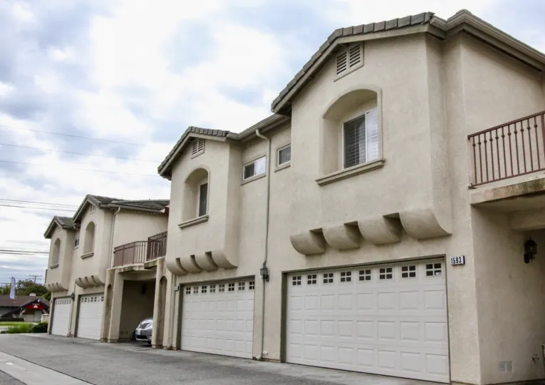 White townhomes with garages and balconies overlooking the street