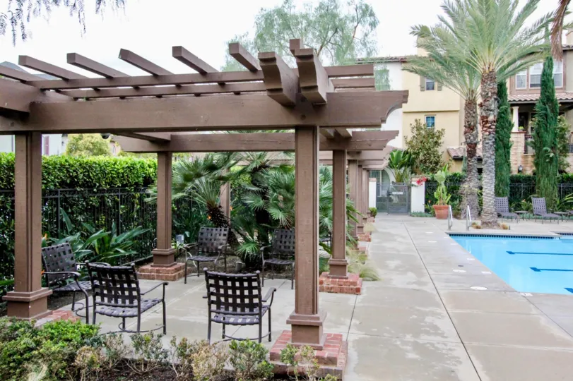 Pool area surrounded by garden with palm trees inside Colony Park community