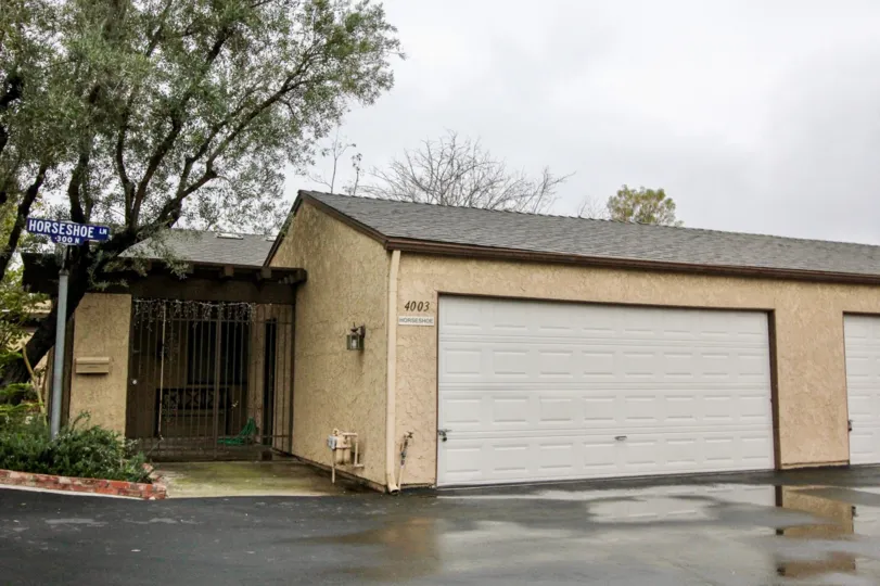 A home and garage viewed from the front yard on a cloudy day in the Gateway Americana community