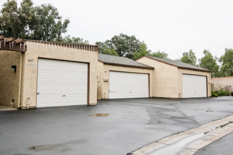 Three garages with white doors in an alleyway inside Gateway americana in Anaheim CA