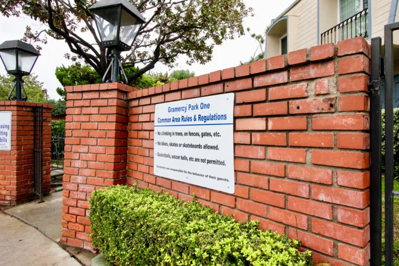 THIS IMAGE SHOWS THE ENTRANCE THAT IS BRICK RED WALL WITH LIGHT LAMP SITUATED IN ANAHEIM CITY