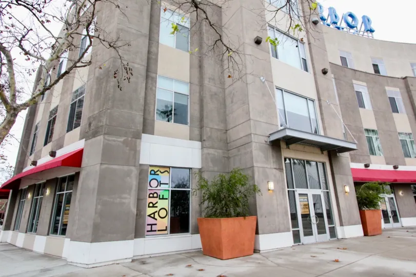 A bright day in the Harbor Lofts with a huge building and a sign.