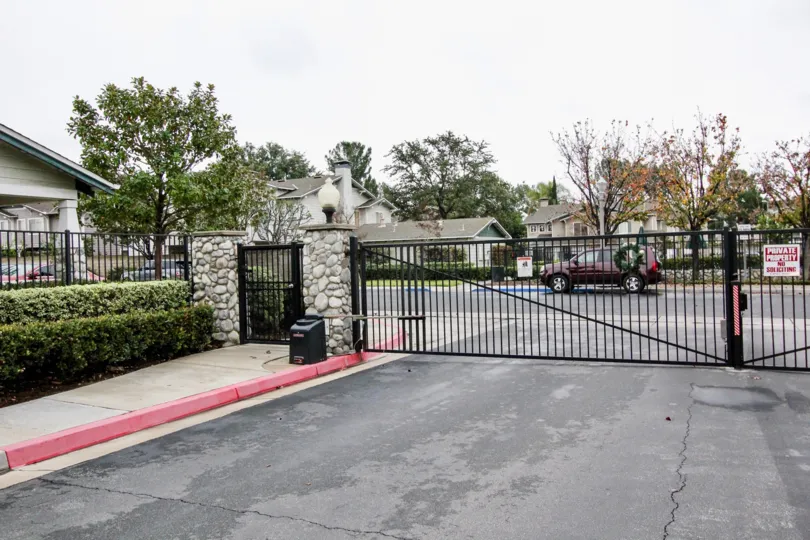 A cloudy day in the Heritage Place Cottages gate closed, speaker placed on the footpath and car parked in front of gate on the road