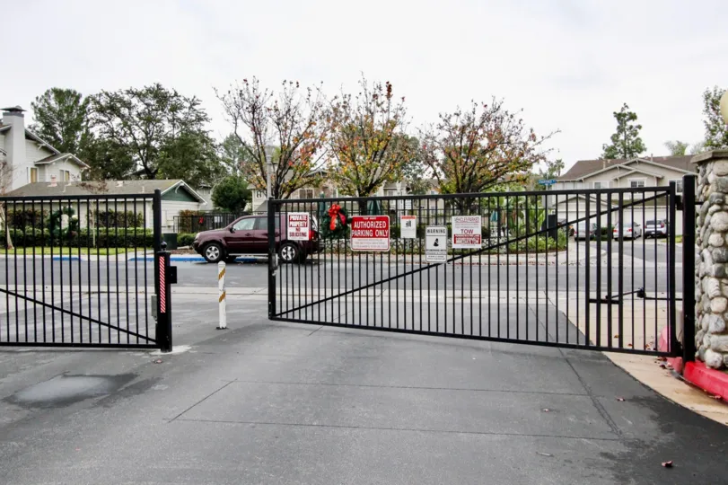 Large metal black gate opes to Heritage Place Cottages community
