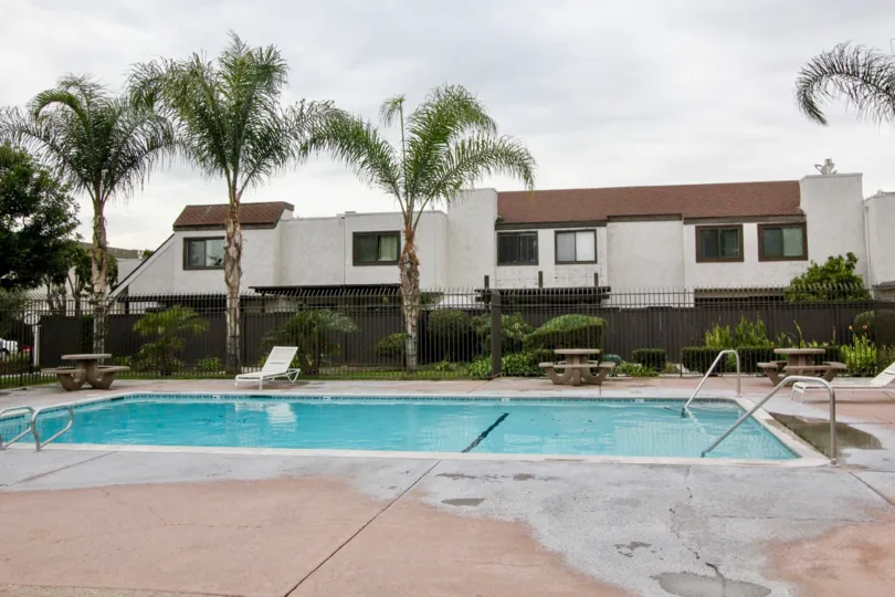 White townhomes with a pool in the Heritage Village Townhomes in the Anaheim, California.