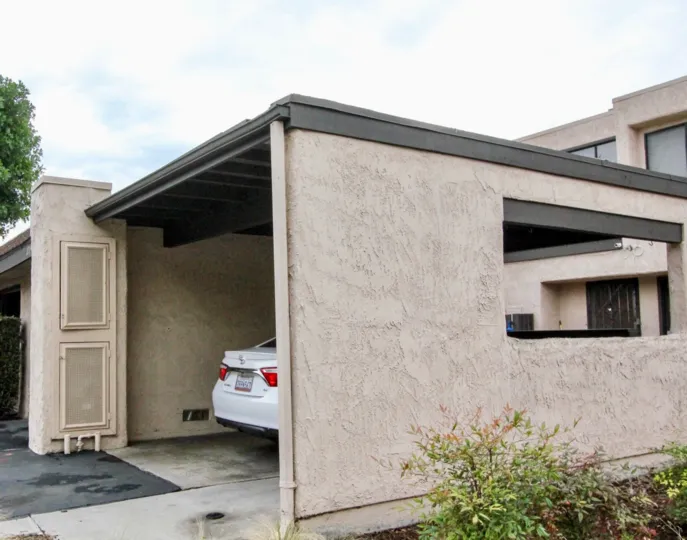 A covered carport, with a white car partially visible, in Heritage Village Townhomes, Anaheim, CA